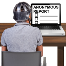 A person using a computer. An online form called an anonymous report form is on the screen.